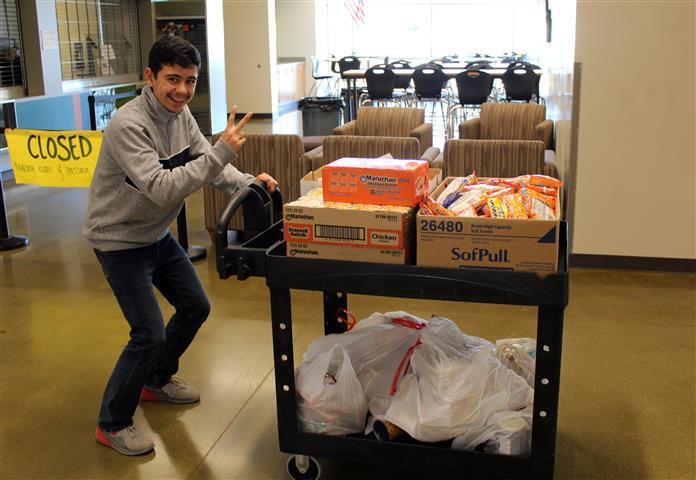 Students using carts to move large quantities of food for donation