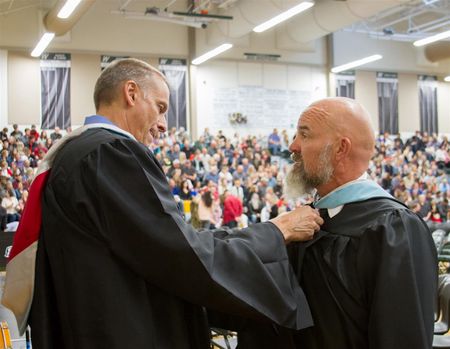 Dan adjusts John's hood right before the commencment ceremony 