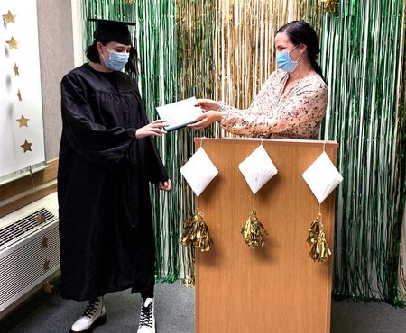 Elizabeth "Liz" Vallaire, Math and Science teacher, presents Dakota Spencer with her diploma during a small commencement ceremony