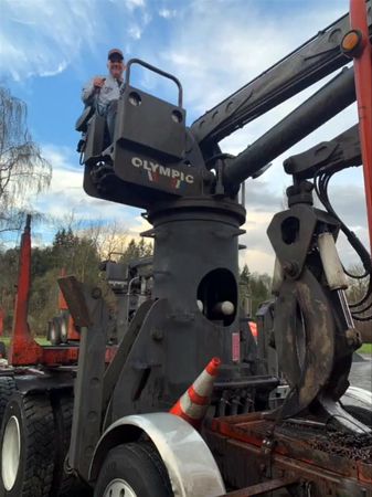 Jim Miller demonstrates how the grappling system on his truck lifts heavy logs and places them on the truck’s loading bed.