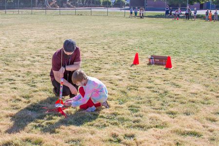 Brian Peterson, 3rd grade teacher, helps a student prepare a rocket for launch