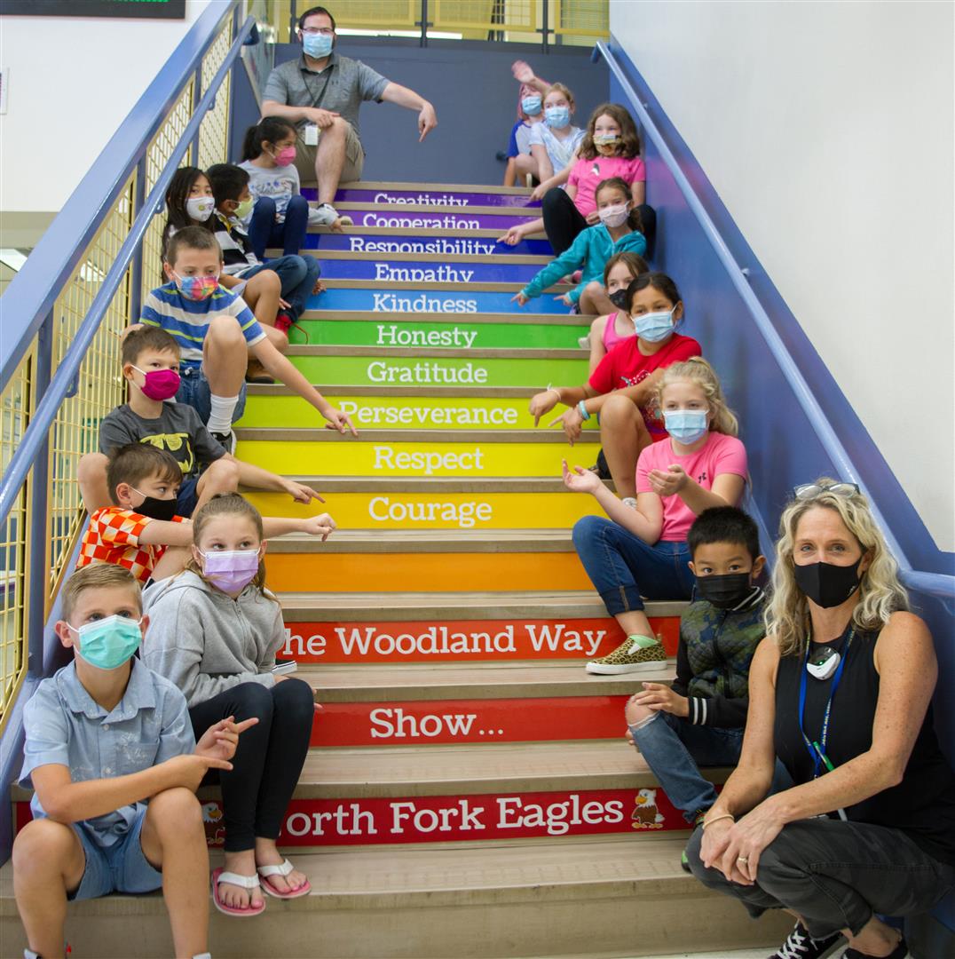 Leadership/SEL Teacher Stacia Aschoff (far right) sits with her leadership class on the stairs of North Fork Elementary School in Woodland, Wash.