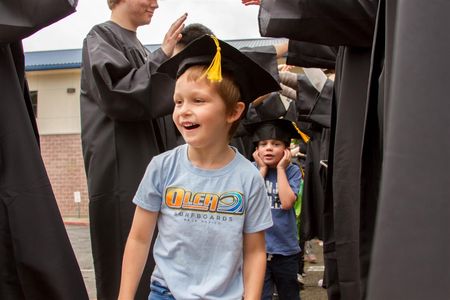 WHS Grads formed a Graduation Tunnel for each elementary's kindergartners students to celebrate their transition to 1st grade