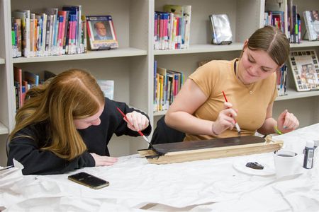 Adison Bergstrom (left) and Olivia Mason (right) decorate a holiday sleigh in Craft Club