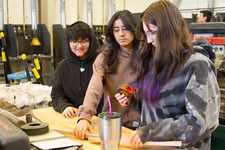 Left to Right: Anahy Juarez, Paula Mora, and Raegen Hanson, all freshmen, measure and cut wood for their project