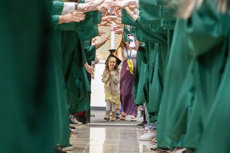 WHS Grads formed a Graduation Tunnel for each elementary's kindergartners students to celebrate their transition to 1st grade