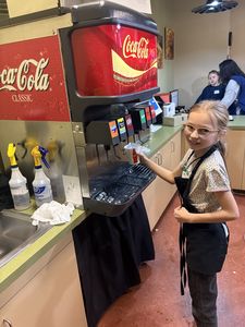Student serving soda at Biz town