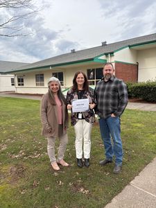 Three people holding a certificate
